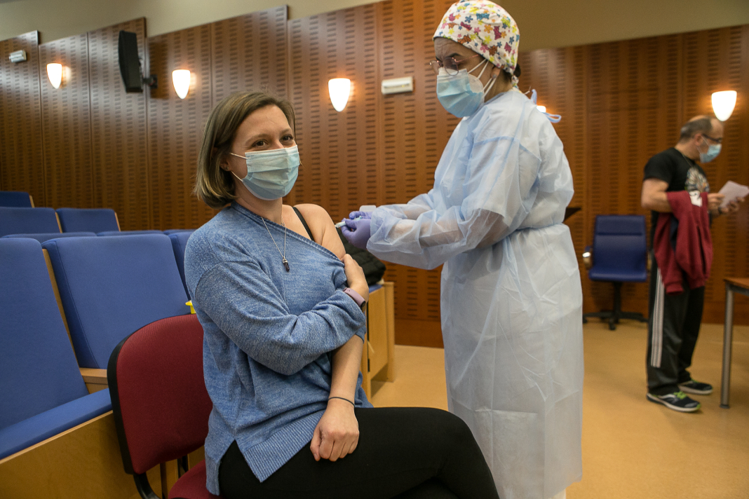 Una profesional sanitaria administra una vacuna de Astrazeneca a una persona